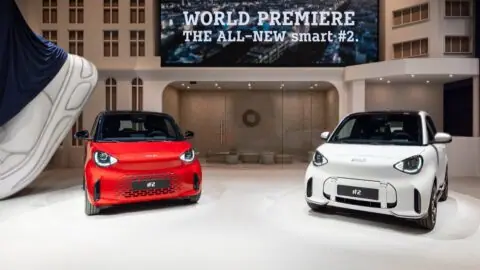 Red and white Smart #2 electric city cars displayed at the model's world premiere.