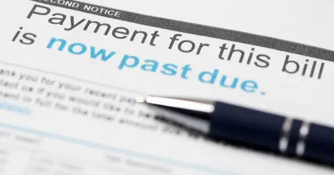 Squeezed by inflation, more Americans fall behind on their debts