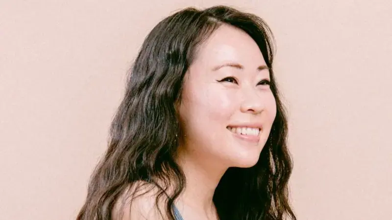 一名深色頭髮的女子面帶微笑。