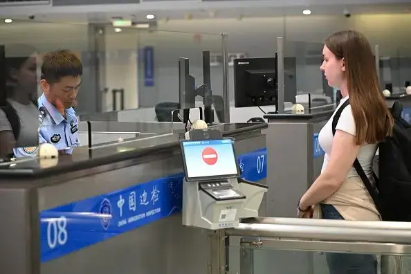 一名外國旅客正在中國某機場的出入境檢查櫃枱接受入境審查。