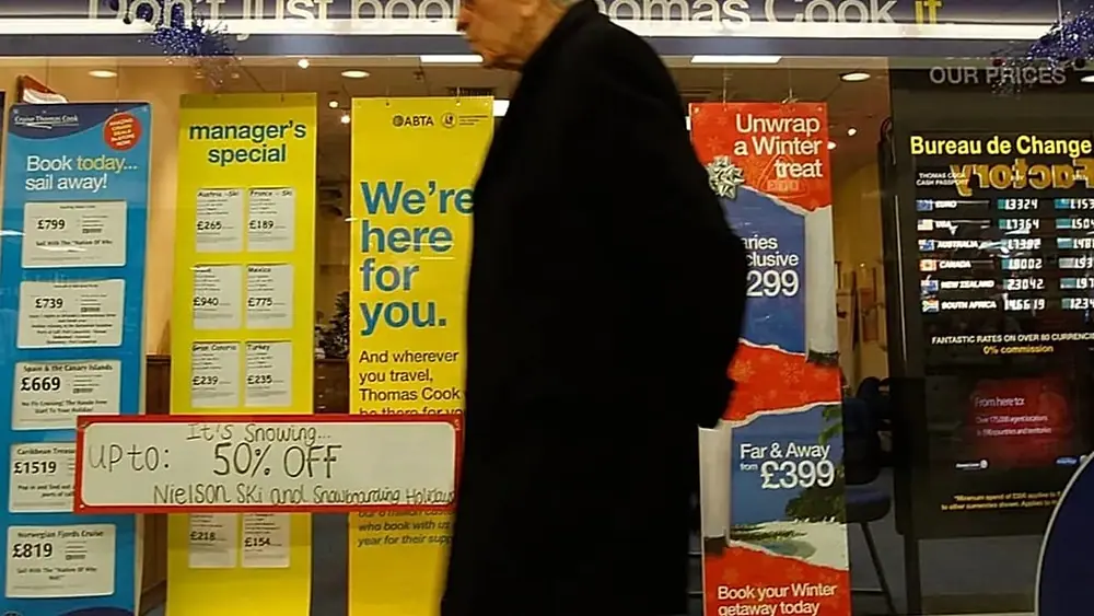 A man walks past a Thomas Cook shop in London, Wednesday, Dec. 14, 2011.