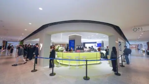 Visitors gather around the curved entrance and illuminated counter of the Firefly store at Bangkok's centralwOrld.