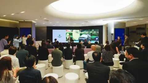 Guests seated in a Firefly showroom watch a presentation on a large screen.