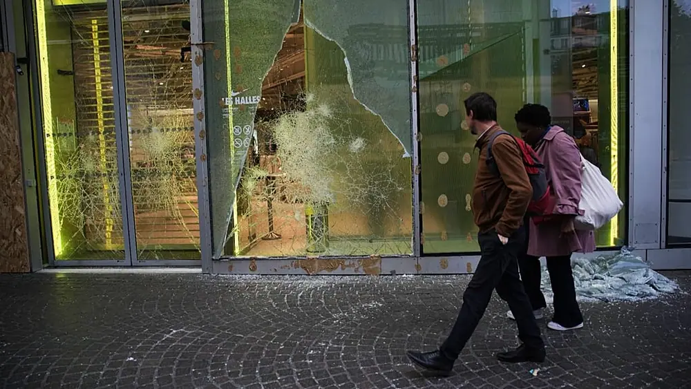 Passers-by survey the damage after violence on the fringes of protests, Paris, Monday 19 October 2026.
