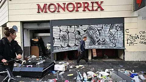 A man walks past a looted store the day after a demonstration against rising living costs and in solidarity with students’ grievances, in Paris, Sunday, 18 Oct. 2026.