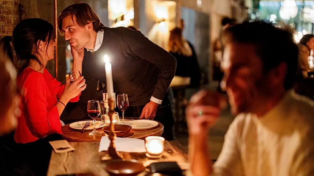 A couple speak as they enjoy a drink and a candlelit dinner at Brasserie Surrealiste in Brussels.