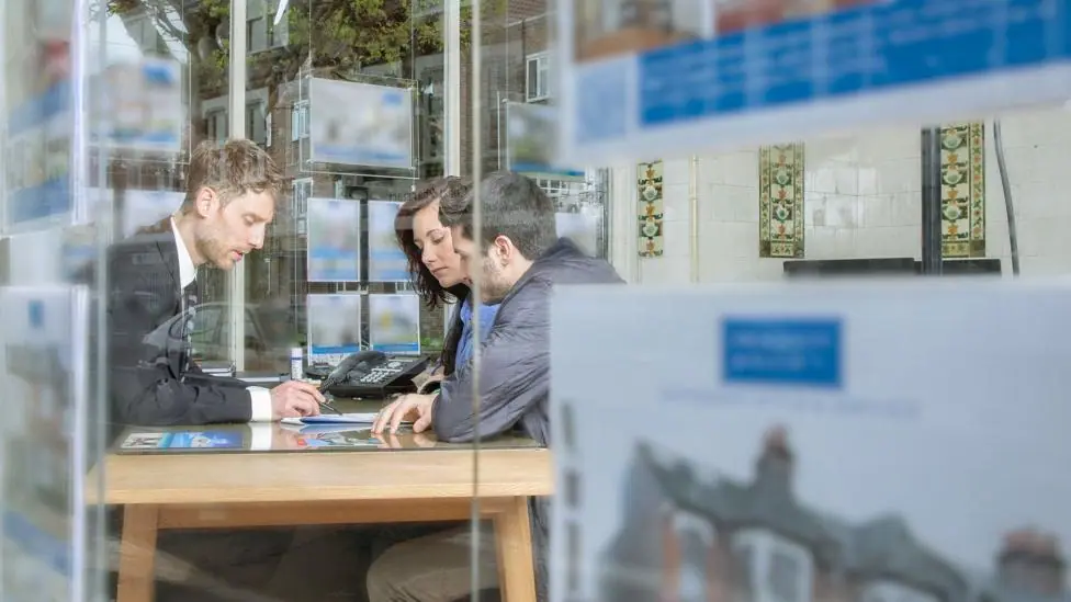 Couple buying a home in an estate agent.