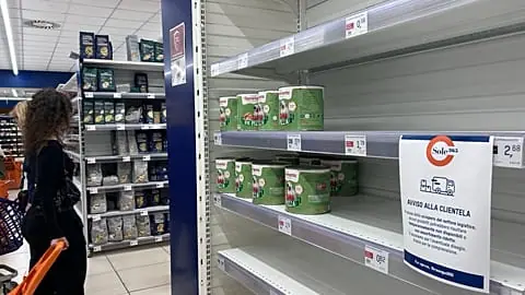 A notice on empty shelves at a supermarket apologizes to customers for the lack of products, due to an ongoing truckers strike in Naples, Italy, Tuesday, Oct. 20, 2026.